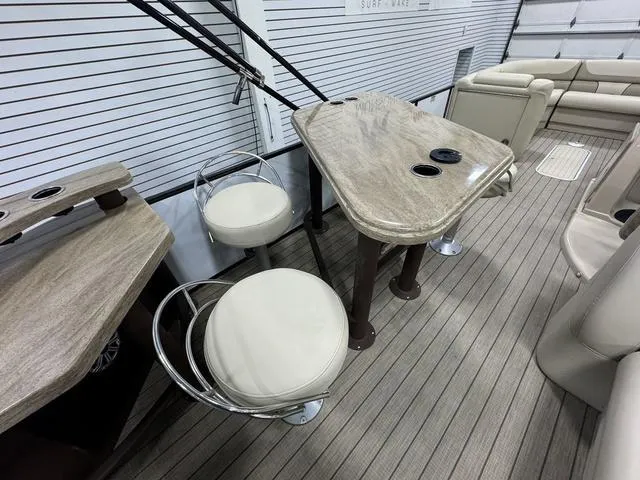 Slide: The Image of 2019 SunChaser 8525 Entertainer boat interior with seating and table setup. - 8