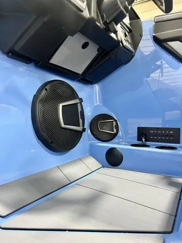 Slide: The Image of 2024 Axis Wake Research T250 interior with speaker, cup holders, and control panel. - 12