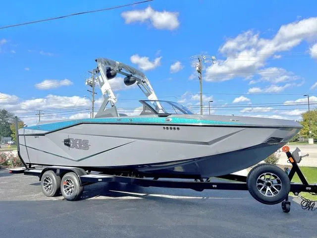 Slide: The Image of 2024 Axis Wake Research T250 boat on trailer under clear blue sky. - 1