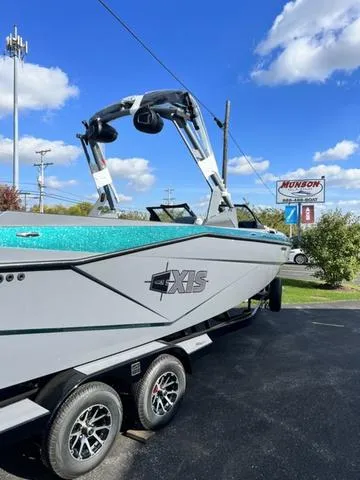 Slide: The Image of 2024 Axis Wake Research T250 boat on trailer, parked outdoors under blue sky. - 3