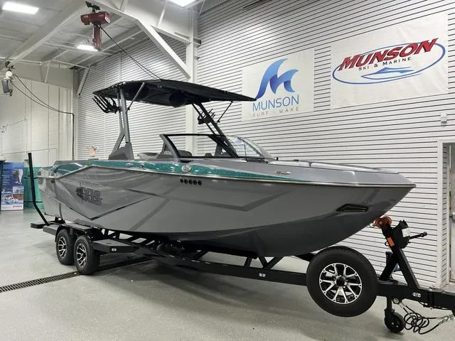 Slide: The Image of 2024 Axis Wake Research T250 boat on trailer in showroom, Munson Ski & Marine signage visible. - 4