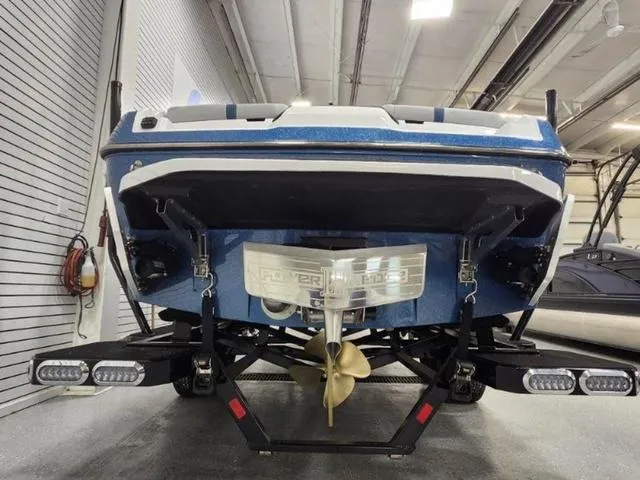 Slide: The Image of 2024 Axis Wake Research A245 boat, rear view in a showroom setting. - 5