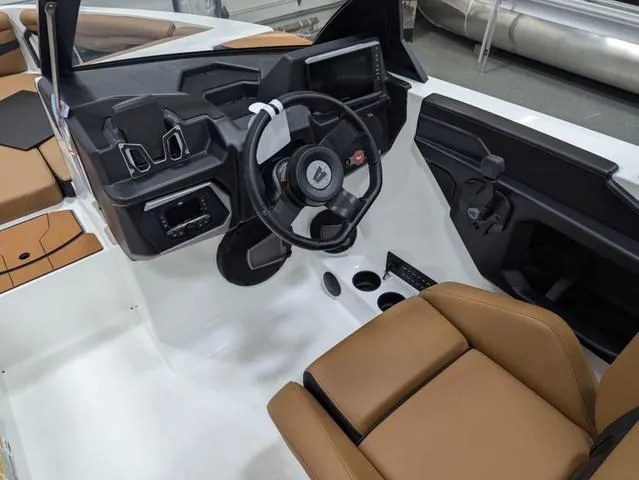 Slide: The Image of 2025 Axis Wake Research T220 boat interior with modern dashboard and tan seating. - 14