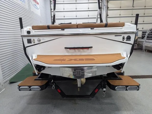 Slide: The Image of 2025 Axis Wake Research T220 boat, rear view in a showroom setting. - 3