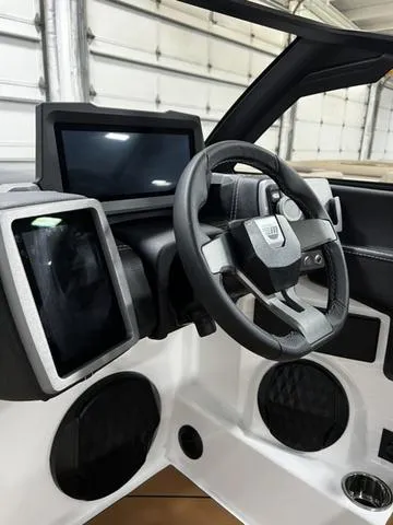 Slide: The Image of 2024 Malibu 22 LSV boat dashboard with modern steering wheel and digital displays. - 16