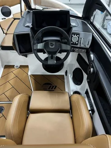 Slide: The Image of 2024 Malibu 22 LSV boat interior with modern dashboard and tan seating. - 17