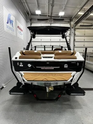 Slide: The Image of 2024 Malibu 22 LSV boat in showroom, rear view with teak deck and seating. - 6