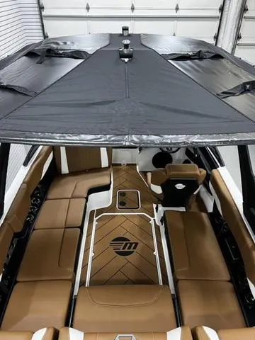 Slide: The Image of 2024 Malibu 22 LSV boat interior with tan seating and sleek design. - 9