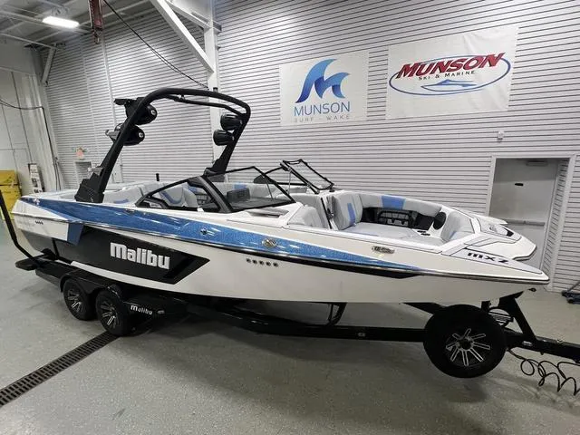 Slide: The Image of 2024 Malibu 24 MXZ boat in showroom, featuring sleek design and modern features. - 3
