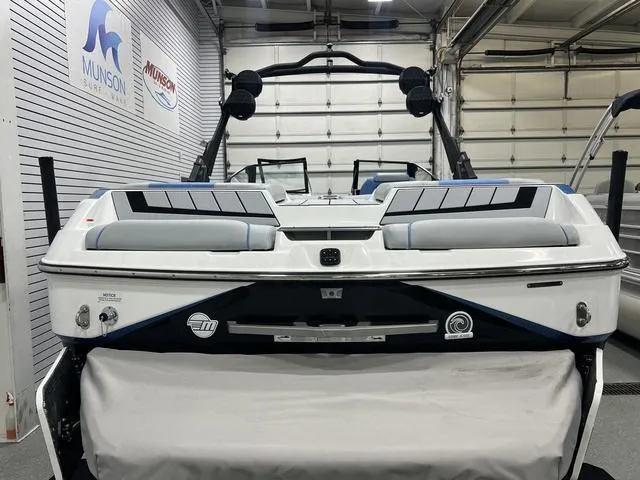 Slide: The Image of 2024 Malibu 24 MXZ boat in showroom, rear view with branding and equipment. - 4
