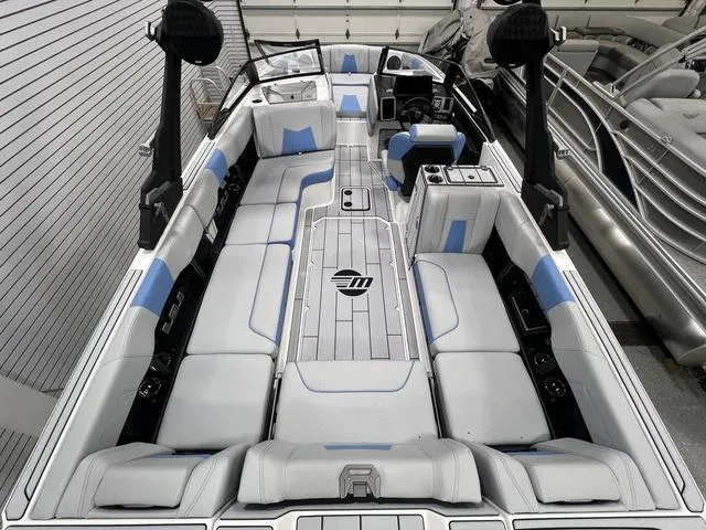 Slide: The Image of 2024 Malibu 24 MXZ boat interior with white and blue seating, sleek design, and modern features. - 6