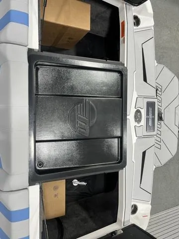 Slide: The Image of 2024 Malibu 21 LX boat interior with storage compartments and sleek design. - 13