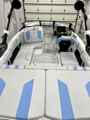 Slide: The Image of 2024 Malibu 21 LX boat interior with blue and gray seating in a garage. - 5