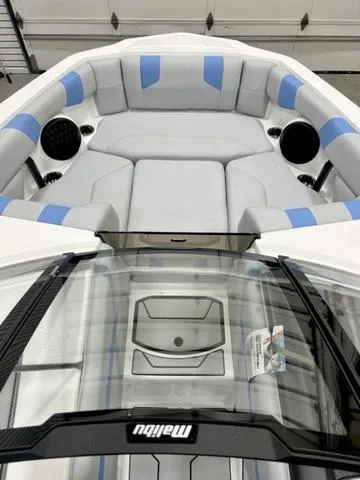 Slide: The Image of 2024 Malibu 21 LX boat interior with gray and blue seating, sleek design. - 7