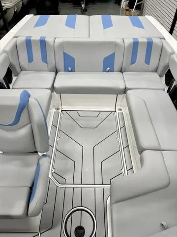 Slide: The Image of 2024 Malibu 21 LX boat interior with gray and blue seating, modern design. - 8