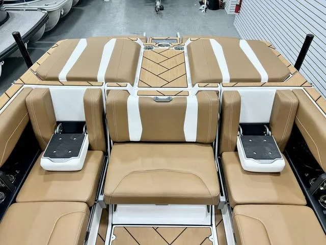Slide: The Image of 2024 Malibu 22 LSV boat interior with tan and white seating arrangement. - 17