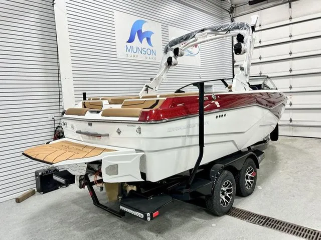 Slide: The Image of 2024 Malibu 22 LSV boat in showroom, red and white design, on trailer. - 3