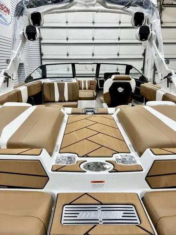 Slide: The Image of 2024 Malibu 22 LSV boat interior with tan and white seating, modern design, and spacious layout. - 5