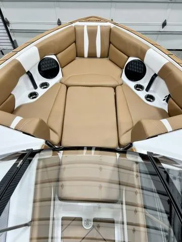 Slide: The Image of 2024 Malibu 22 LSV boat interior with tan and white cushioned seating. - 7