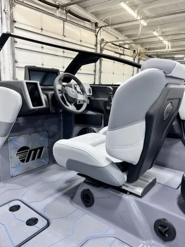 Slide: The Image of 2024 Malibu 23 MXZ boat interior with modern dashboard and sleek seating design. - 11