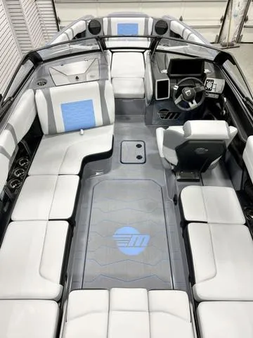 Slide: The Image of 2024 Malibu 23 MXZ boat interior with modern seating and dashboard design. - 6