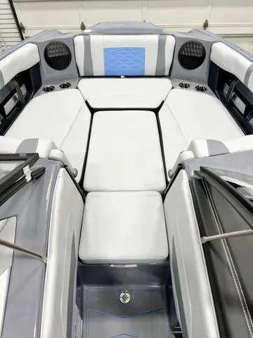Slide: The Image of 2024 Malibu 23 MXZ boat interior with sleek white and gray seating. - 8