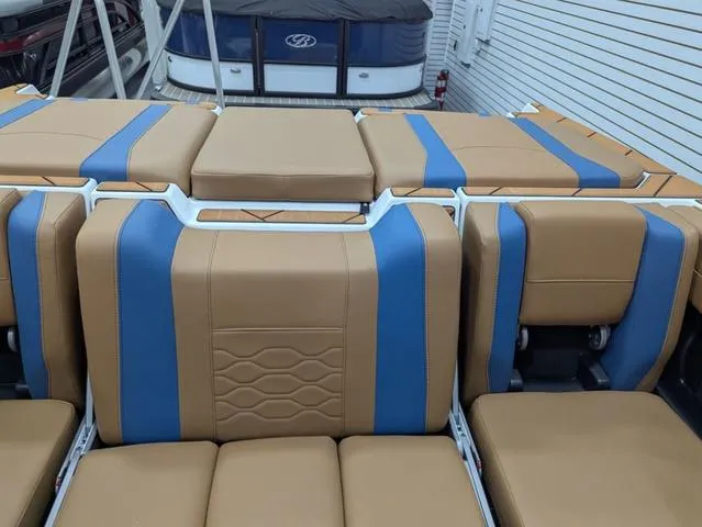 Slide: The Image of 2025 Malibu 23 LSV boat interior with tan and blue seating. - 11