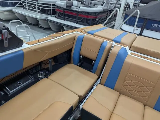 Slide: The Image of Luxurious interior of 2025 Malibu 23 LSV boat with tan and blue seating. - 12