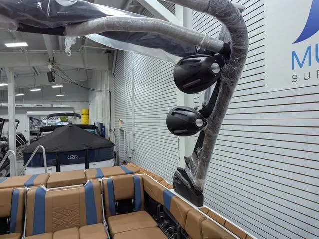 Slide: The Image of 2025 Malibu 23 LSV boat interior with speakers in a showroom setting. - 16