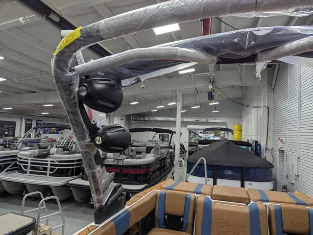 Slide: The Image of 2025 Malibu 23 LSV boat in showroom, wrapped tower, luxury seating. - 17