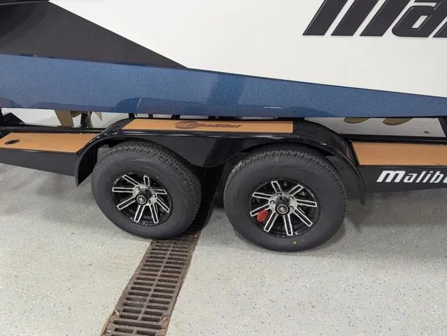 Slide: The Image of Trailer wheels of a 2025 Malibu 23 LSV boat on display. - 4