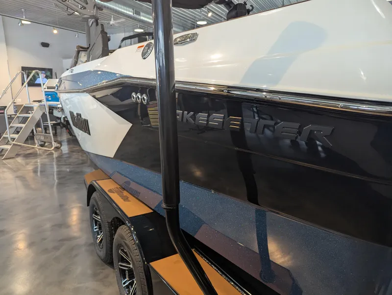 Slide: The Image of 2025 Malibu Wakesetter 23 LSV boat in showroom, side view with trailer. - 5