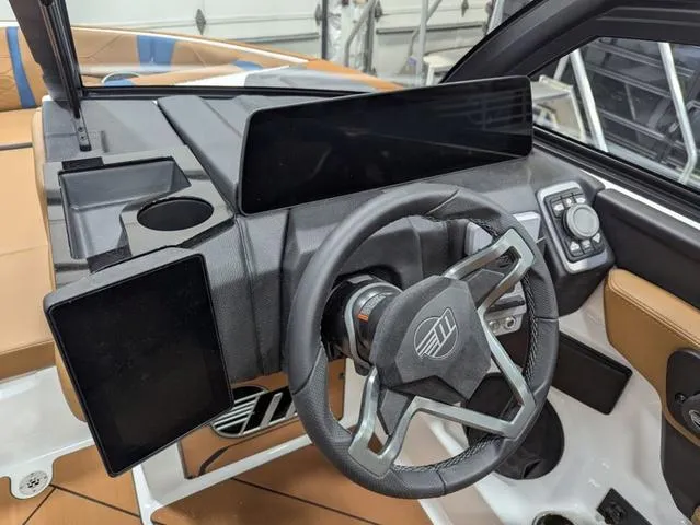 Slide: The Image of 2025 Malibu 23 LSV boat dashboard with modern steering wheel and digital displays. - 8