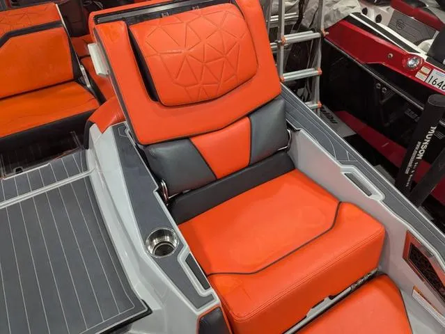 Slide: The Image of Orange and gray seating on 2020 Nautique G23 Paragon boat, featuring modern design and cup holder. - 13