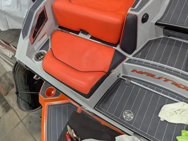 Slide: The Image of 2020 Nautique G23 Paragon boat interior with orange seating and gray flooring. - 14