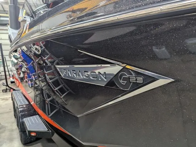 Slide: The Image of 2020 Nautique G23 Paragon boat with sleek black exterior in a garage setting. - 2