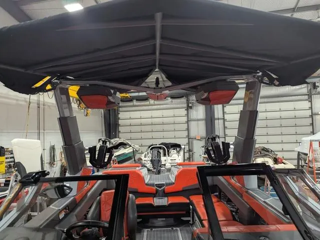 Slide: The Image of 2020 Nautique G23 Paragon boat interior with red seating and black canopy in a garage. - 22