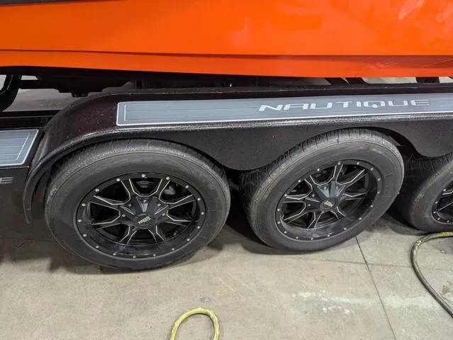Slide: The Image of Trailer wheels of a 2020 Nautique G23 Paragon boat, featuring sleek black rims. - 24