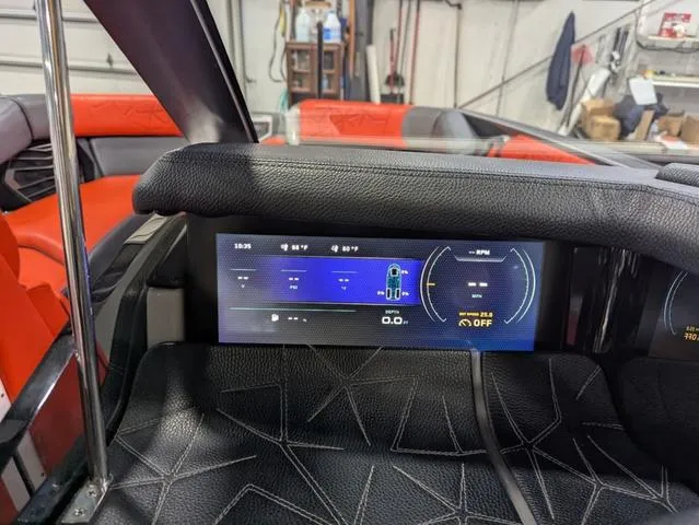 Slide: The Image of 2020 Nautique G23 Paragon dashboard with digital display in a garage setting. - 38
