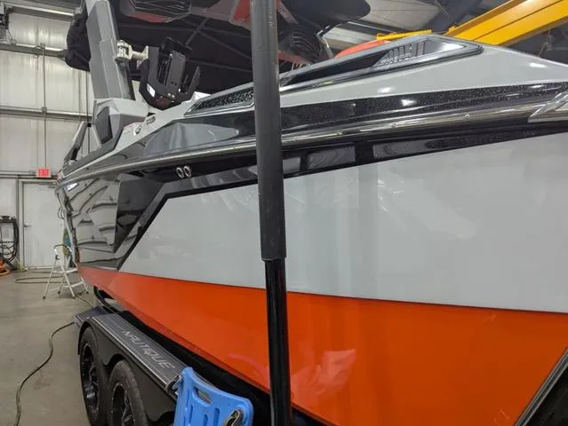 Slide: The Image of 2020 Nautique G23 Paragon boat in a garage, featuring sleek design and vibrant orange accents. - 8