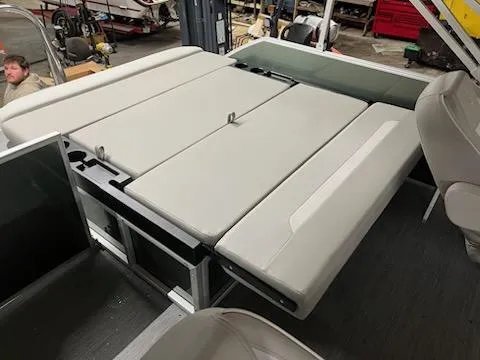 Slide: The Image of 2025 Godfrey 2286SFLX boat interior with beige seating and storage compartments. - 10