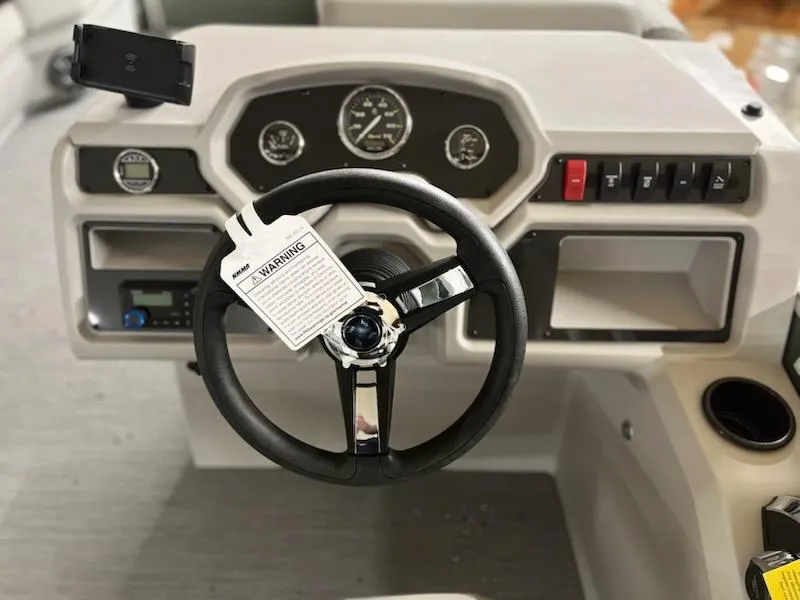 Slide: The Image of Steering wheel and dashboard of 2025 Godfrey 2286SFLX boat, featuring gauges and controls. - 16