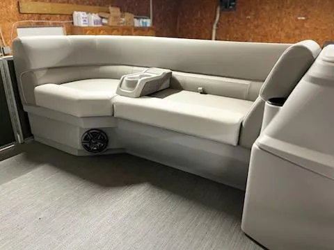 Slide: The Image of 2025 Godfrey 2286SFLX boat interior with beige seating and speaker. - 18