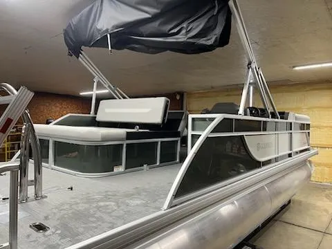 Slide: The Image of 2025 Godfrey 2286SFLX pontoon boat in indoor storage, featuring sleek design and covered seating. - 5