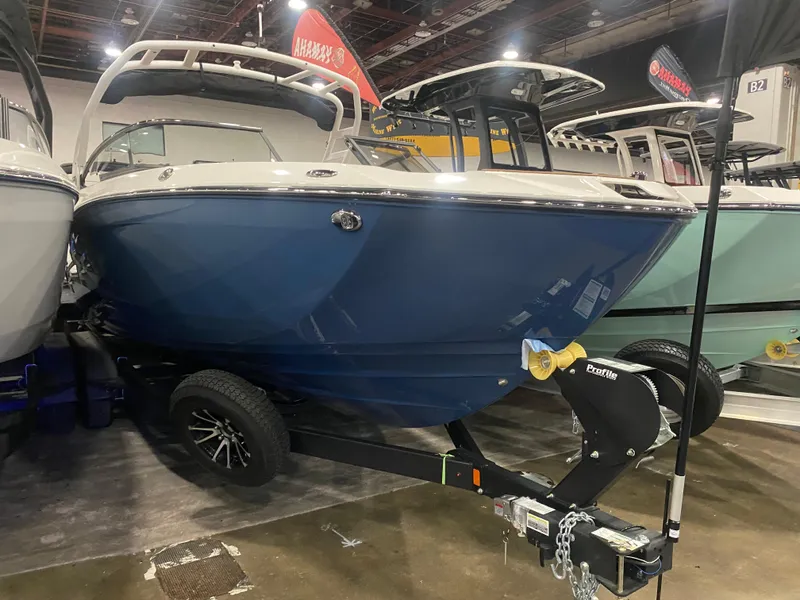 Slide: The Image of 2025 Yamaha Boats 252S, blue hull, displayed indoors on a trailer. - 7