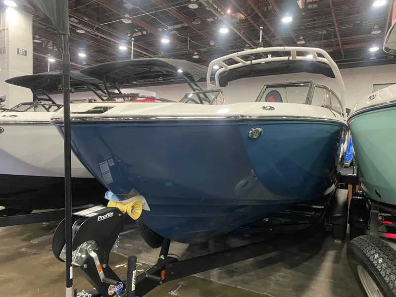 Slide: The Image of 2025 Yamaha Boats 252S, blue hull, displayed indoors on a trailer. - 8