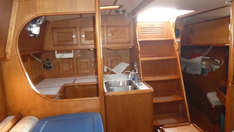 Slide: The Image of Interior of 1990 Celestial 48 Center Cockpit yacht with wooden cabinetry and compact kitchen. - 14