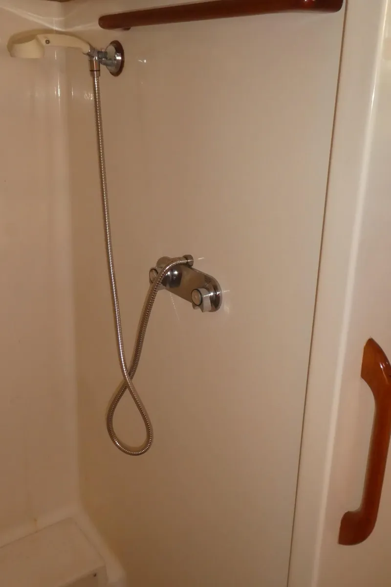 Slide: The Image of Shower area in 1990 Celestial 48 Center Cockpit yacht, featuring handheld showerhead and wooden handle. - 22