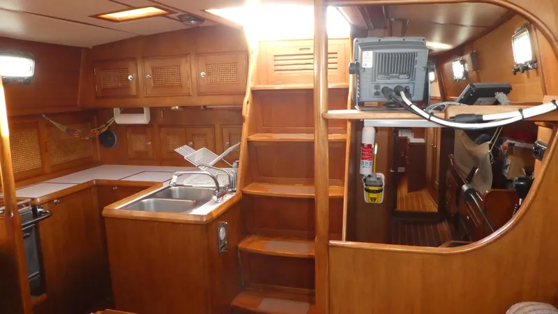 Slide: The Image of Interior of 1990 Celestial 48 Center Cockpit yacht with wooden cabinetry and kitchen area. - 25