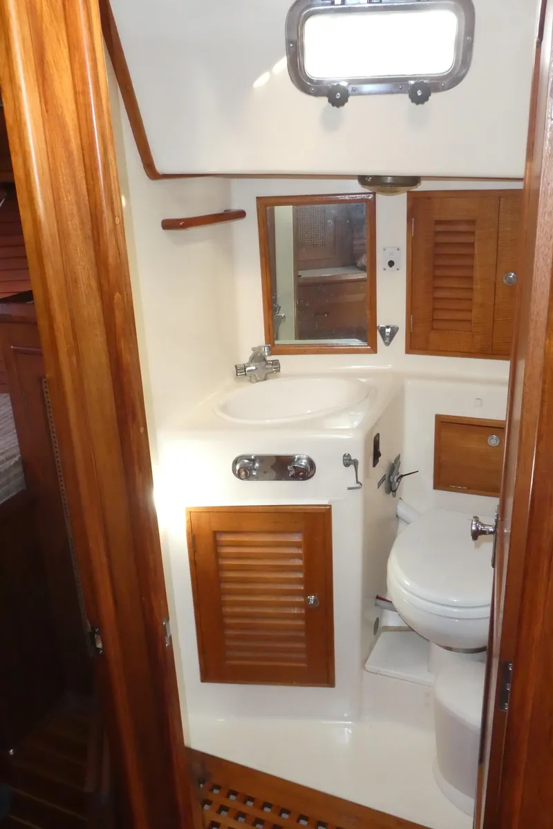 Slide: The Image of 1990 Celestial 48 Center Cockpit bathroom with wooden cabinets and compact design. - 28